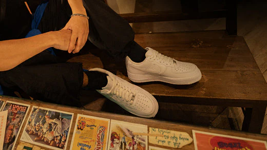 “1982 Nike Air Force 1 basketball sneaker on hardwood court, showing leather panels and classic Nike Air cushioning design.”