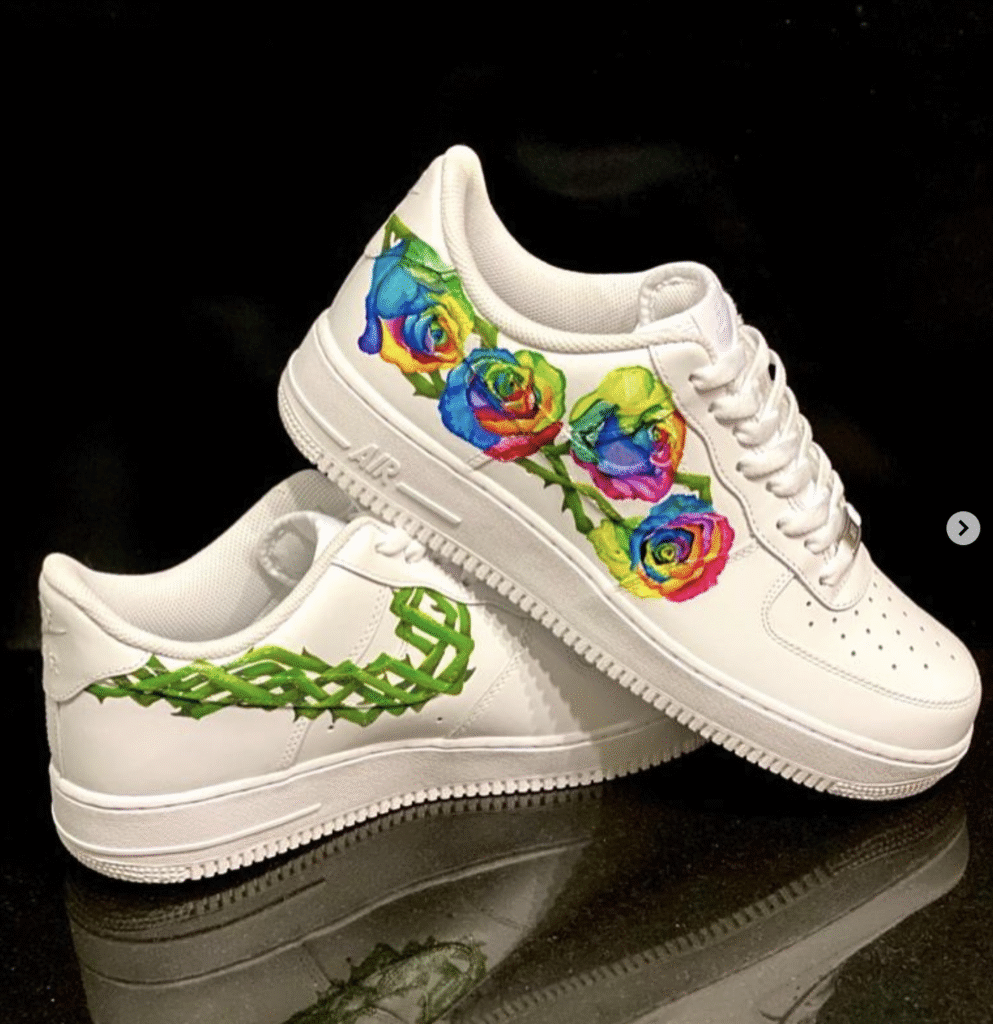 “Close-up of an artist painting a custom design on a white Air Force 1 sneaker, showing brushes, acrylic paints, and detailed leather surface.”